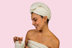 Woman applying moisturizing cream to body for healthy skin